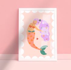 a pink wall with a mermaid print on it and a white frame against the wall