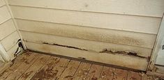 the corner of a house that has been gutted with wood flooring and water damage