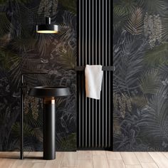 a black and gold bathroom with palm leaves on the wall next to the radiator