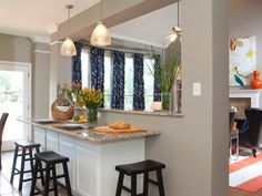 a kitchen with three stools and a center island in front of the counter top