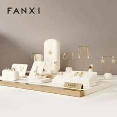 an assortment of jewelry on display in front of a gray background with the word fanxi