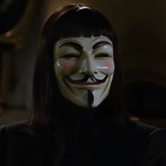 a woman wearing a guy fawk mask with long black hair and dark brown eyes