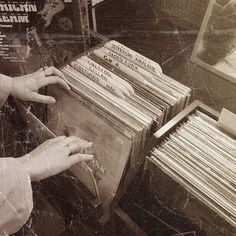 a woman is looking at records in a record store