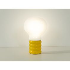 a yellow light bulb sitting on top of a white table