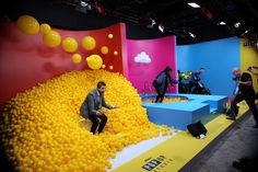 a man sitting on a bench surrounded by yellow balls