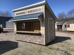 a small building with a metal roof and windows