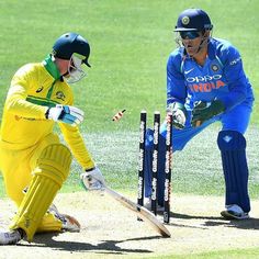 two men in blue and yellow uniforms playing cricket