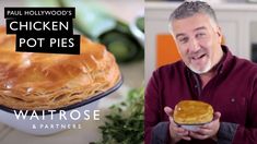 a man holding a pot pie in front of a cake on top of a table