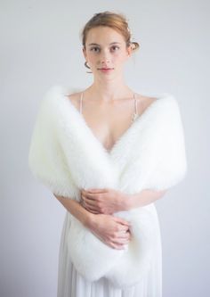 a woman wearing a white dress and fur stole