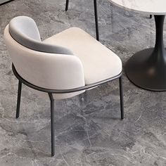 two white chairs sitting next to each other on top of a marble floored floor