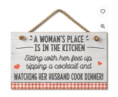 a woman's place is in the kitchen sign hanging on a rope with hearts