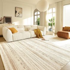 a large white couch sitting on top of a rug in a living room