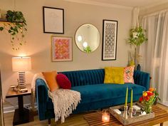 a living room filled with furniture next to a window covered in curtains and pictures on the wall