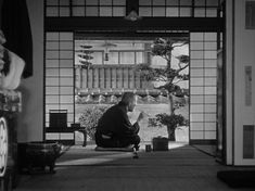 an old man sitting on a bench in front of a window