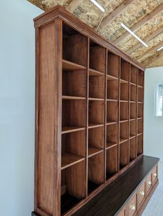 an empty bookcase in the corner of a room with wooden beams on the ceiling