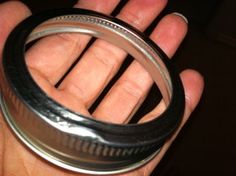 a hand holding a metal ring in it's palm with the bottom part visible