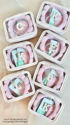 six small plastic containers filled with pink items