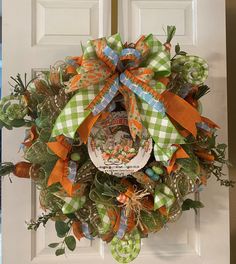 a wreath on the front door decorated with green, orange and white ribbons for st patrick's day