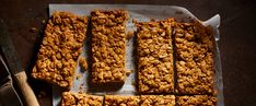 granola bars cut into squares and placed on a baking sheet next to a knife