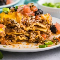 a white plate topped with layered mexican lasagna