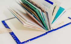 an open book sitting on top of a blue and white table next to a pair of scissors