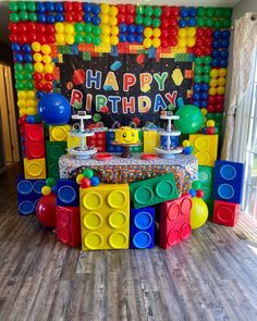 a birthday party setup with legos and balloons on the wall, including an ice cream stand