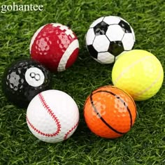 four different types of golf balls sitting on the grass with one ball in the middle