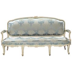 an antique style couch with blue and white fabric