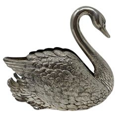 a metal swan figurine on a white background