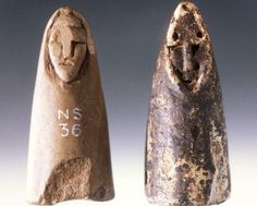 two old stone figurines with faces on them