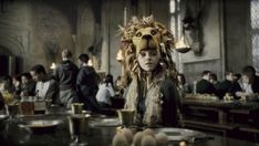 a woman with a lion mask on sitting at a table in front of other people