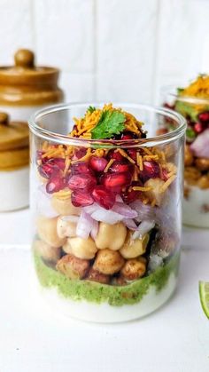 a glass jar filled with food sitting on top of a white counter next to other dishes