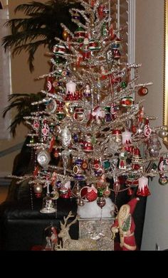 a silver christmas tree with ornaments on it