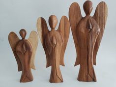 three wooden figurines are standing next to each other