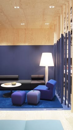 a living room filled with furniture next to a blue carpeted floor and wooden walls