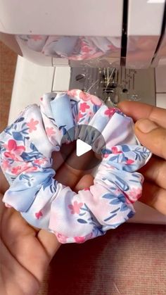 someone is using a sewing machine to sew fabric on the top of a flowered headband