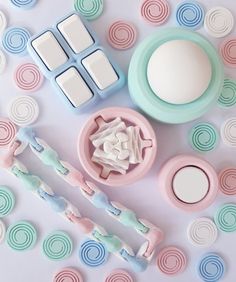 some pastel colored items are laying out on a white surface with circles around them