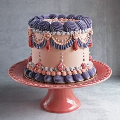 a pink and purple cake sitting on top of a plate