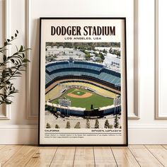 a framed photograph of dodger stadium in los angeles, california on a wooden floor