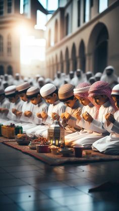 many men are sitting on the ground and praying in front of each other, all dressed in white