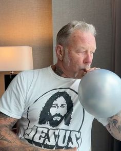 a man blowing on a balloon in his bedroom