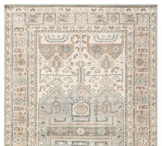 a beige and blue rug with an intricate design on the bottom, in front of a white background