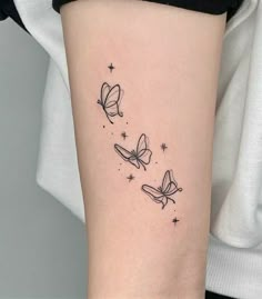 a woman's arm with three butterflies on it, and stars in the background