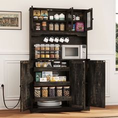 an open cabinet with food items in it and a microwave on the top, next to a window