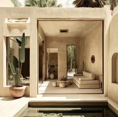 an indoor swimming pool in the middle of a house with palm trees and plants around it