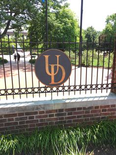 an iron gate with a sign that reads u and has the letter u on it