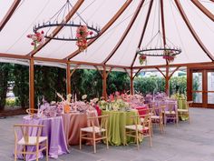 a large tent with tables and chairs set up for a wedding or other formal event