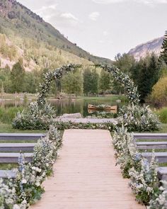 an outdoor ceremony setup with flowers and greenery