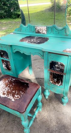 a turquoise vanity with cow hide rug on it