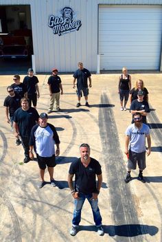 a group of people standing in front of a garage